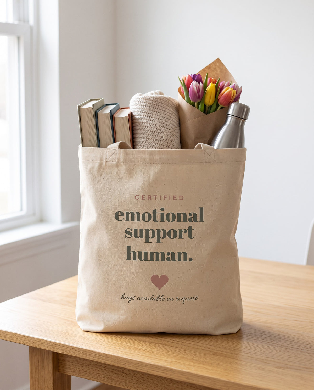 Emotional Support Human Tote, packed with books, a knit sweater, tulips and a water bottle