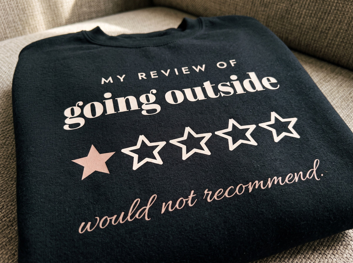 Going Outside, One Star Crewneck, the print up close on black fleece: MY REVIEW OF going outside, one star out of five and would not recommend.
