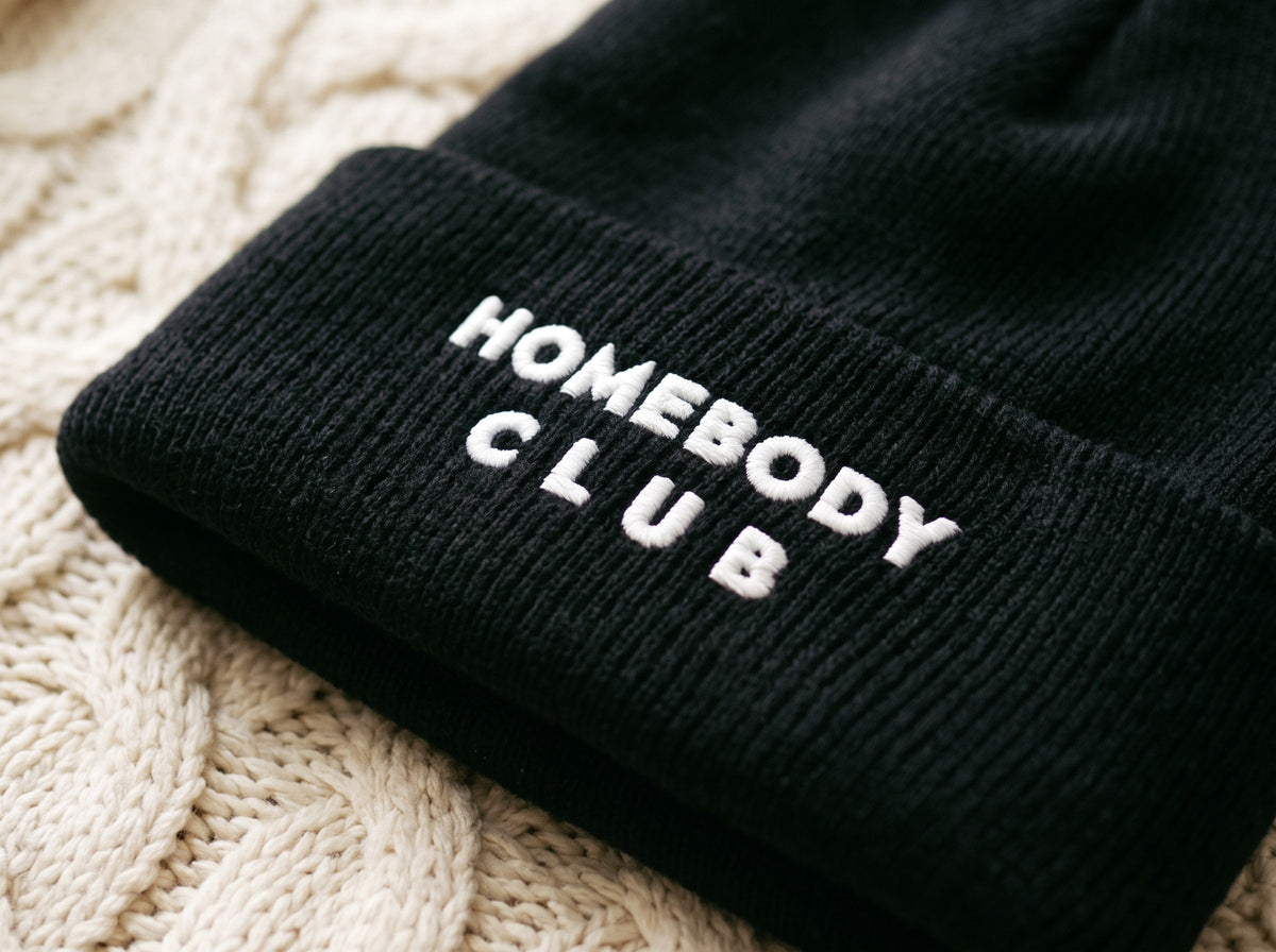 Homebody Club Beanie, the embroidery up close on the black cuff: HOMEBODY CLUB.