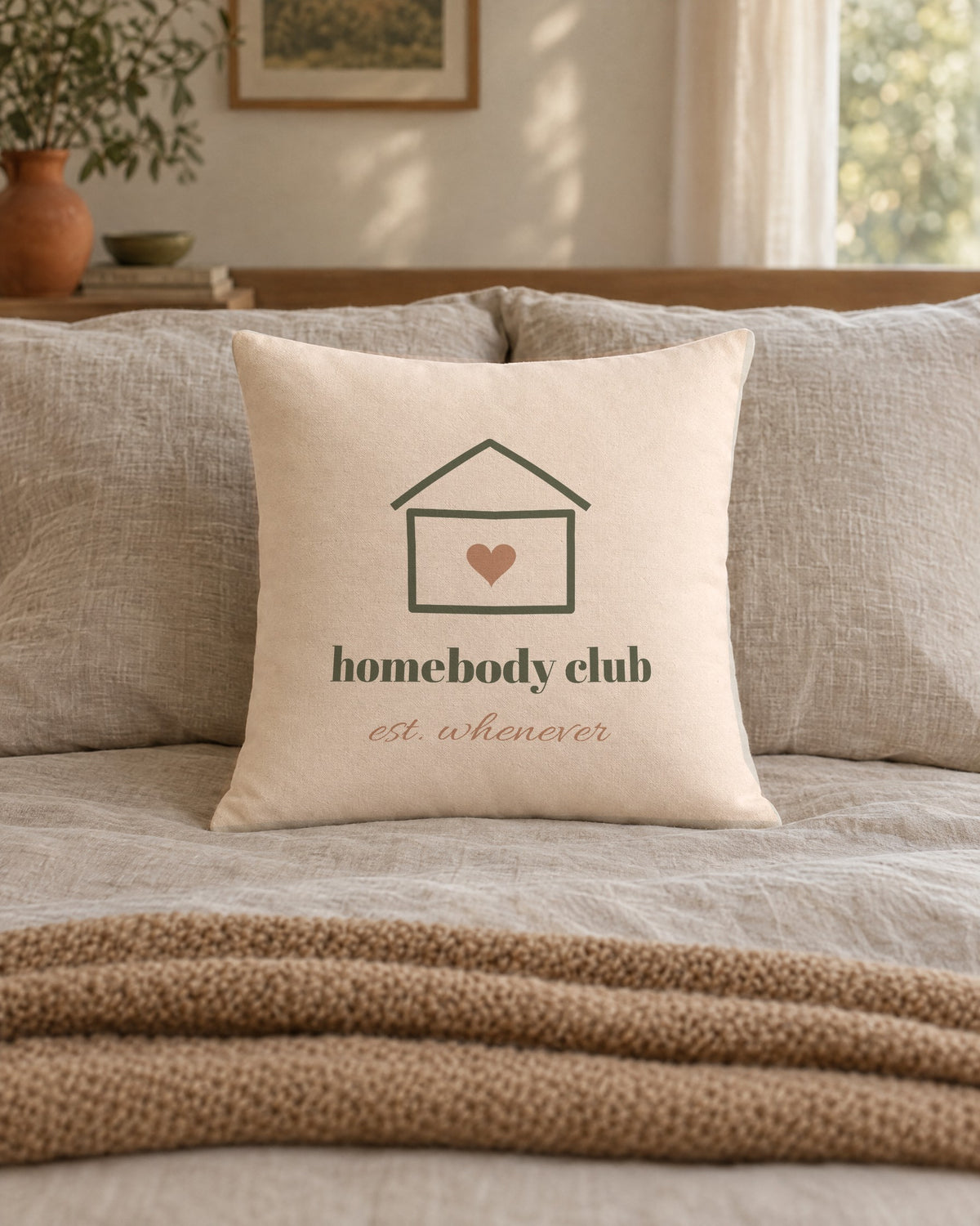 Homebody Club Pillow, 18 x 18 in, on a made bed
