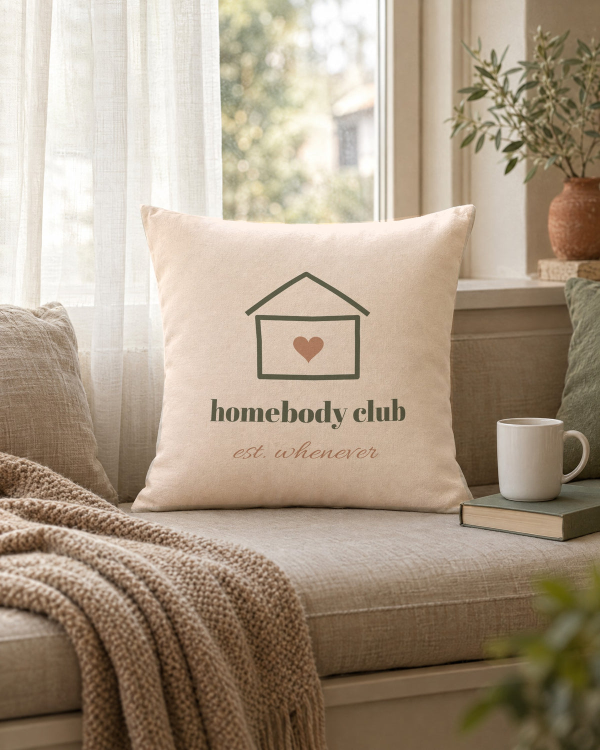 Homebody Club Pillow, 18 x 18 in, propped on a window seat