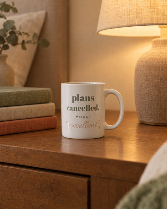 Plans Cancelled Mug, white ceramic 11 oz, on a bedside table by a lamp