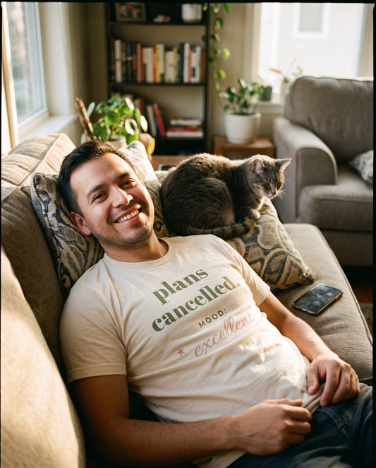 Plans Cancelled Tee, worn on the sofa with a cat