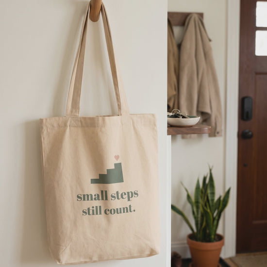 Small Steps Still Count Tote, a short clip of it hanging on a hallway peg in soft daylight