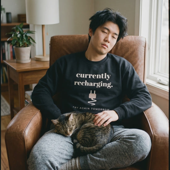 Currently Recharging Crewneck, a short clip of dozing in an armchair with a sleeping cat