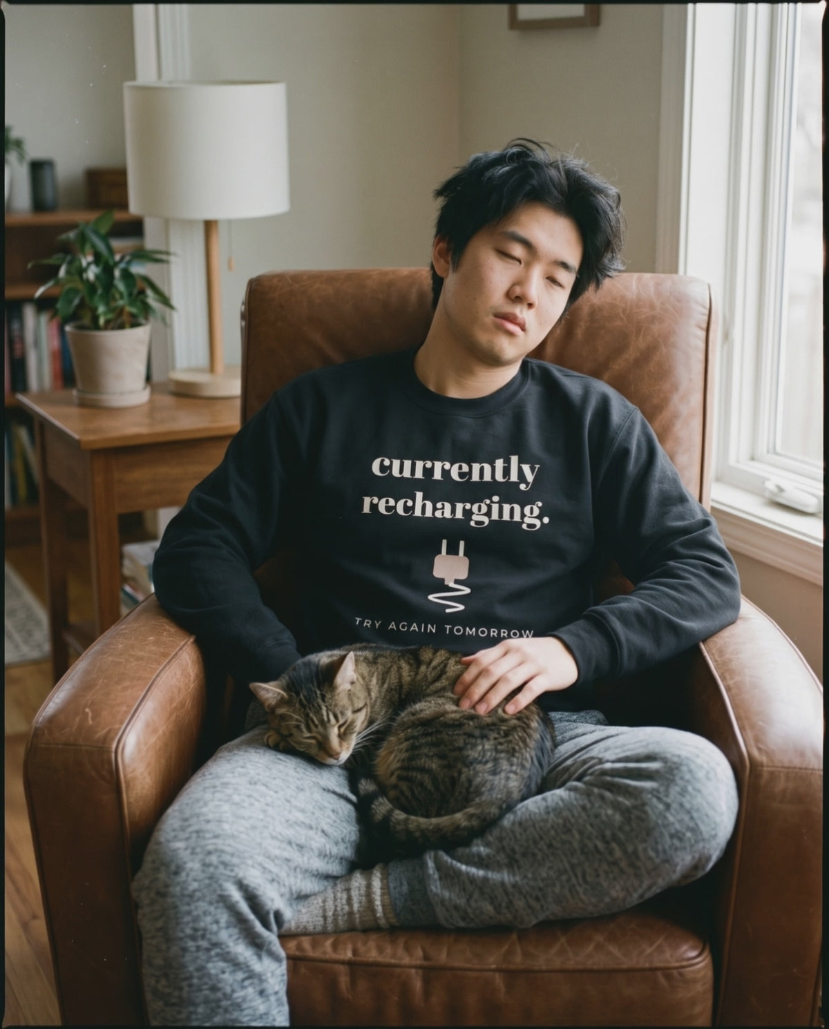Currently Recharging Crewneck, a short clip of dozing in an armchair with a sleeping cat
