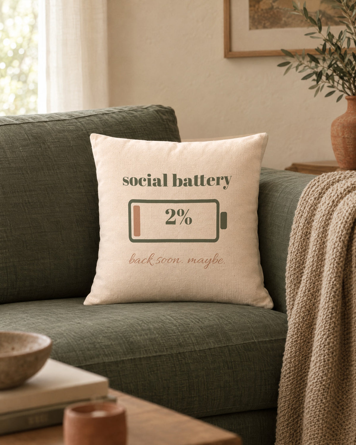 Social Battery Pillow, 18 x 18 in, on a sage linen sofa