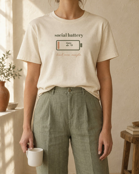 Social Battery Tee, in soft cream, worn with sage linen trousers