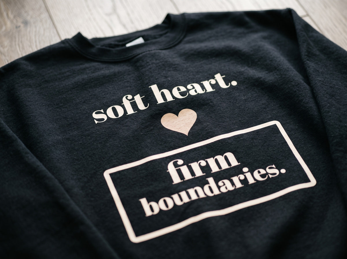 Soft Heart, Firm Boundaries Crewneck, the print up close on black fleece: soft heart., a heart and firm boundaries. in a box.