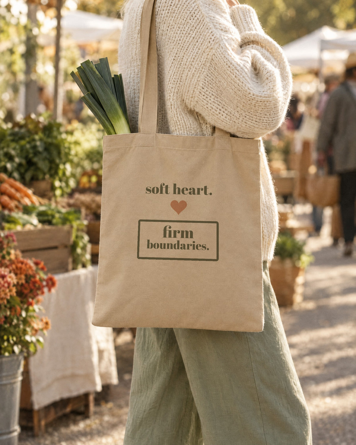 Soft Heart, Firm Boundaries Tote, in natural oyster, carried on the shoulder at a market
