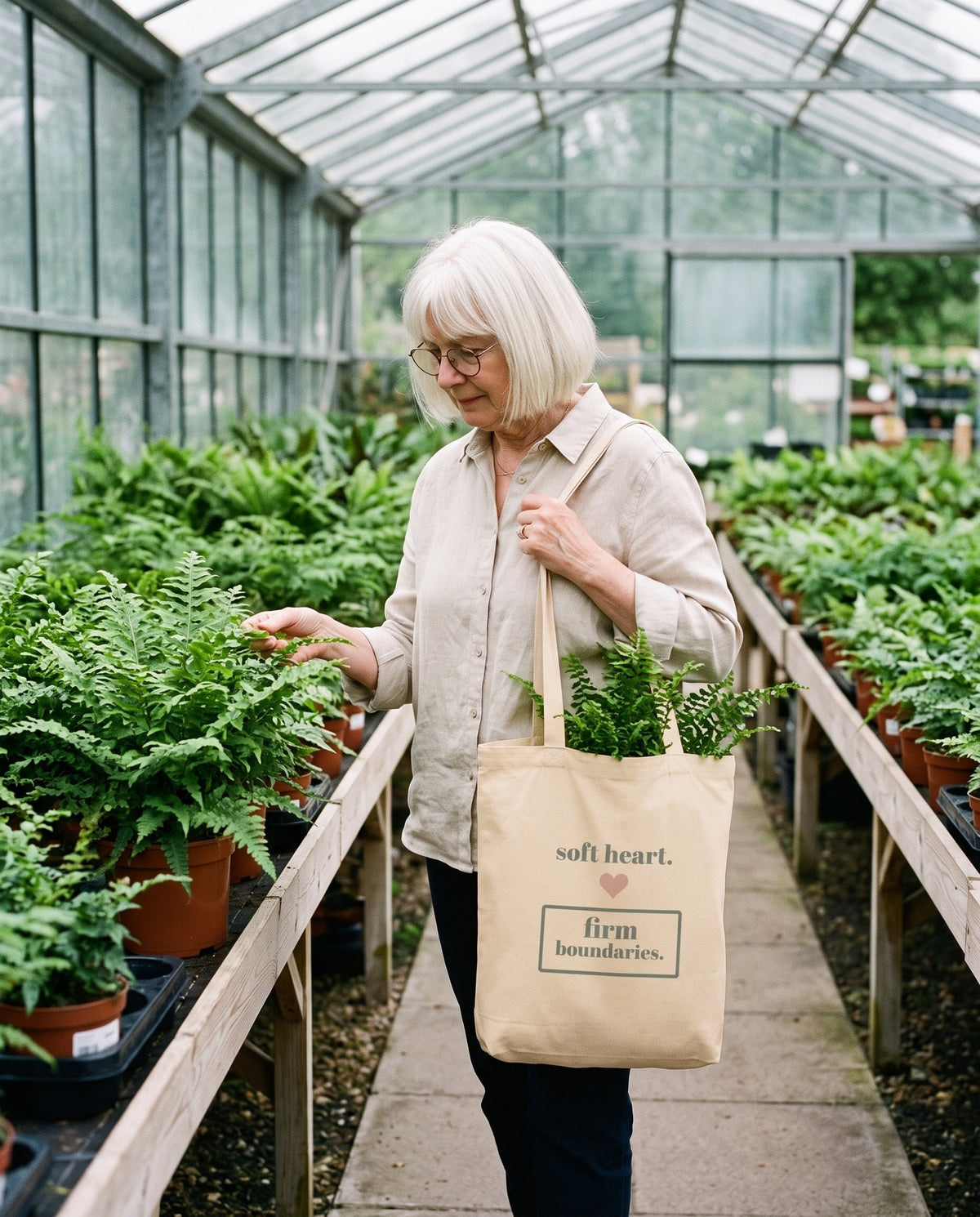 Soft Heart, Firm Boundaries Tote, carried through a greenhouse
