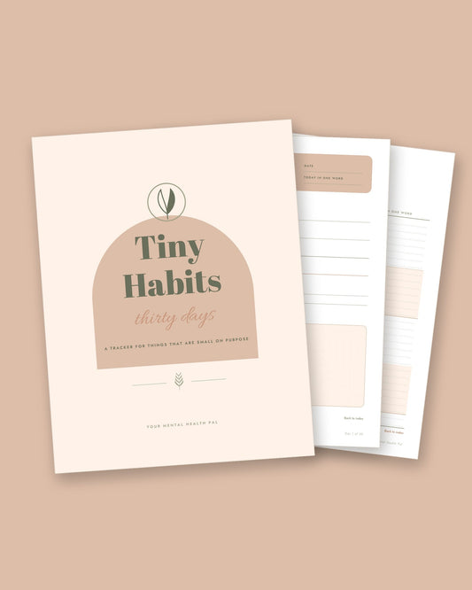 Tiny Habits 30 Day Tracker printable, the cover and two inside pages fanned out on a sand background
