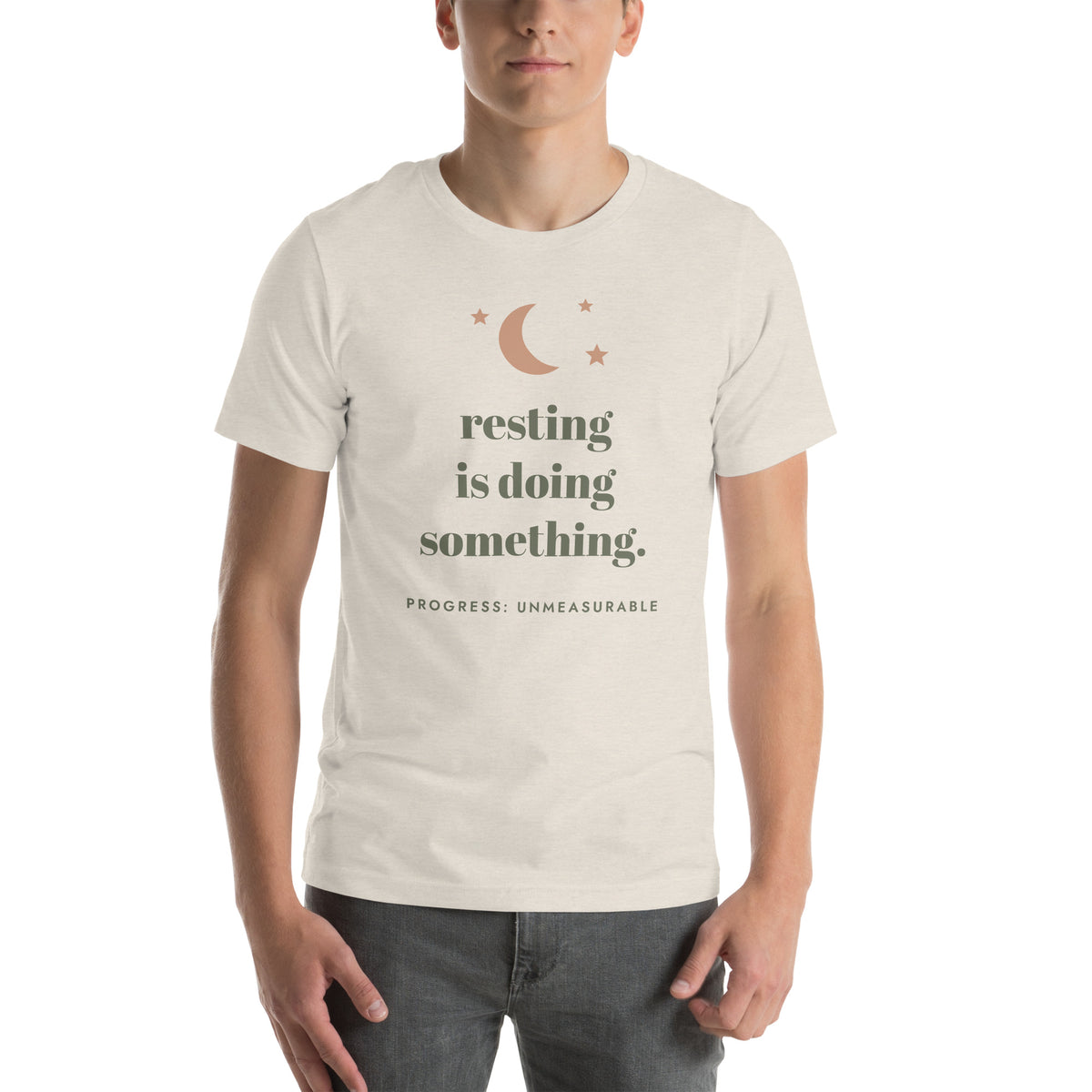 Resting Is Doing Something Tee in Heather Dust, worn by a model, front print: resting is doing something, progress: unmeasurable