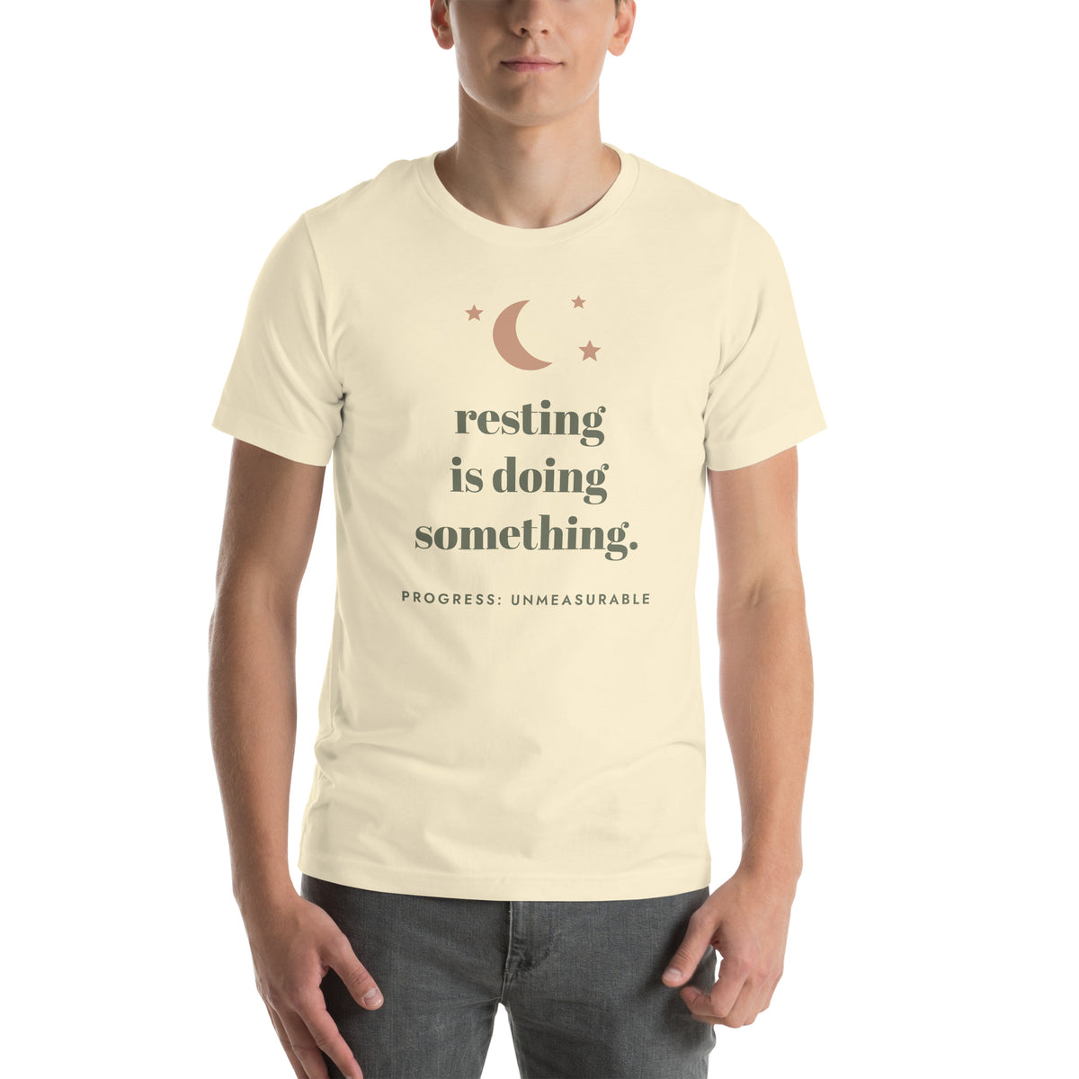 Resting Is Doing Something Tee in Natural, worn by a model, front print: resting is doing something, progress: unmeasurable