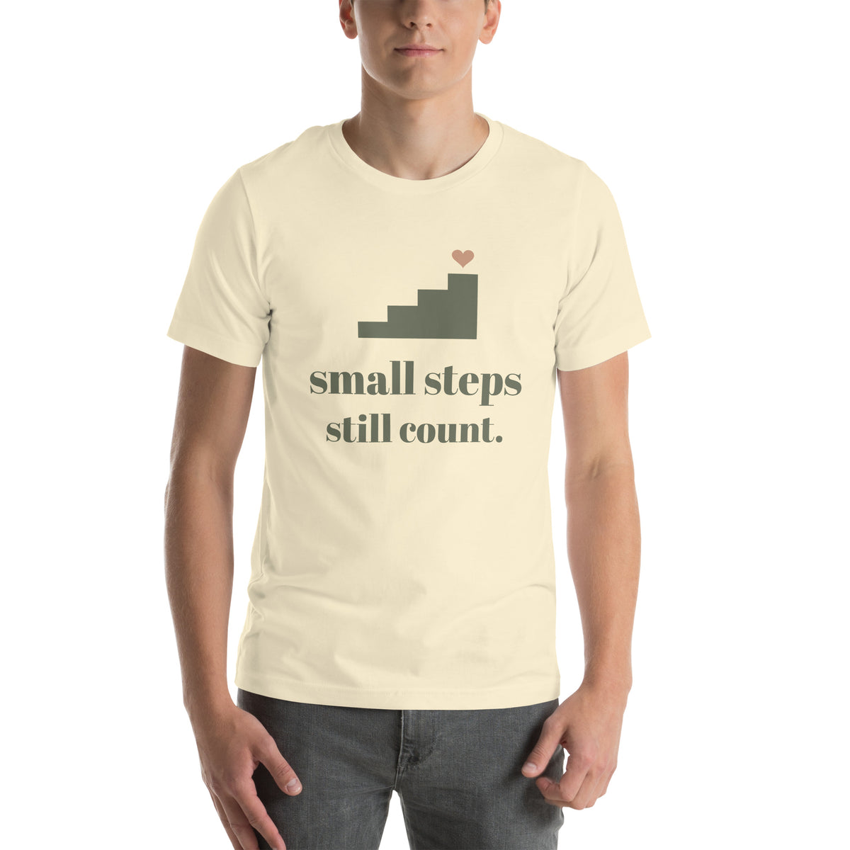 Small Steps Still Count Tee in Natural, worn by a model, front print: a small staircase with a heart, small steps still count