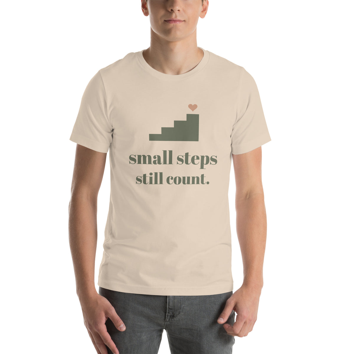 Small Steps Still Count Tee in Soft Cream, worn by a model, front print: a small staircase with a heart, small steps still count